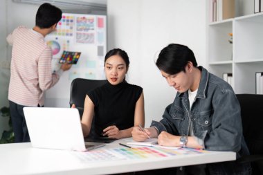 Odaklanmış bir ekip, canlı renk örnekleriyle çevrili iken, profesyonel etkileşim ve yaratıcılığa olan tutkusunu gösteren yeni tasarım kavramlarını keşfeder..