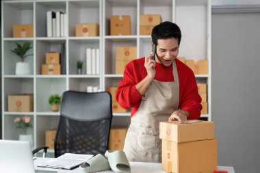 Hevesli bir girişimci, e-ticaret işinin dinamik doğasını vurgulayarak bir telefon görüşmesinde ambalaj ve nakliye sürecini yönetir..