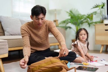 Bir baba ve kızı okul malzemelerini organize ederken yeni bir okul yılının heyecanı ve hazırlığını sergiliyorlar..