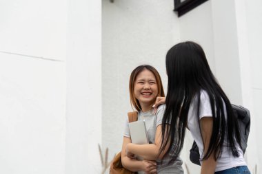 İki sınıf arkadaşı, okul dışında bir anlık kahkaha ve bağlantının keyfini çıkararak eğitim yolculuğundaki arkadaşlığın önemini vurguluyor..