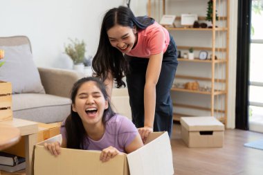 Paketleri açarken, iki kadın neşeli bir anı paylaşıyor, yeni yaşam alanlarının tadını çıkarırlarken eğlence-sever dinamiklerini sergiliyorlar.