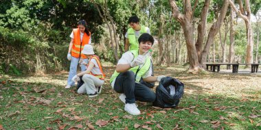 Bir grup gönüllü parkta toplanıyor, çöpleri topluyor ve temizlik günlerinde birbirlerini en iyi çevre uygulamaları hakkında eğitiyorlar..