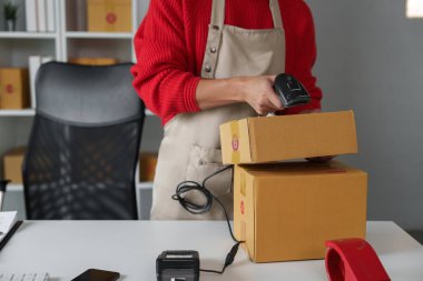 Adanmış bir girişimci, e-ticaret dünyasında sipariş hazırlama sürecinin titiz bir şekilde gösterildiği ürünleri teslim etmek için tarar..