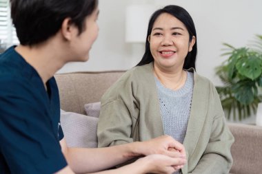 İlgili bir doktor, gülümseyen bir hastayla iletişim kurar. Sağlık ortamında empati ve profesyonellik gösterir..