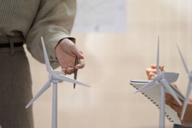 Dinamik bir toplantıda, profesyoneller rüzgar enerjisi çözümlerini araştırarak, sürdürülebilir bir gelecek için takım çalışması ve stratejik planlamayı vurguluyorlar.