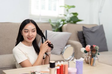 Genç bir kadın evde saç stili yapmaktan hoşlanır düz ütüyle, güçlü ve kendinden emin hisseder..