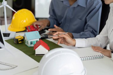 Bir mühendis ekibi sürdürülebilir ev tasarımları üzerinde işbirliği yaparak yeşil teknoloji ve çevresel sorumluluğu birleştiren yenilikçi çözümleri araştırıyor..