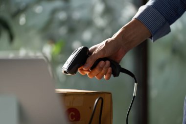 Parlak bir başlangıç ortamında operasyonel verimliliği artırmak için el bilgisayarı ile paket işleme üzerinde yoğunlaşan Asyalı bir girişimci.