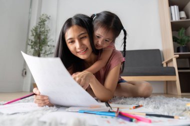 Bir anne ve kız, sanat eserlerini incelerken, öğrenme ve cesaretlendirme yoluyla ilişkilerini geliştirdikleri mutlu bir anı paylaşıyorlar..