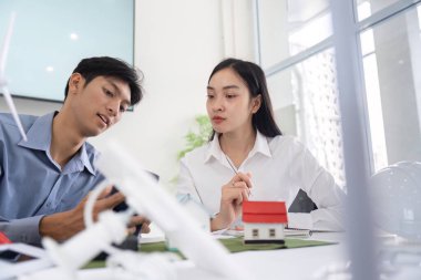 İki genç profesyonel sürdürülebilir mühendislik modelleri ve bunların çevre üzerindeki potansiyel etkileri hakkında düşünceli bir tartışmaya giriştiler..