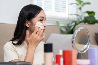 Bir kadın makyaj uygulamasına odaklanıyor, yeteneklerini sergiliyor ve güzellik rutinine olan güvenini dile getiriyor, günlük cilt bakımını güçlendiriyor..