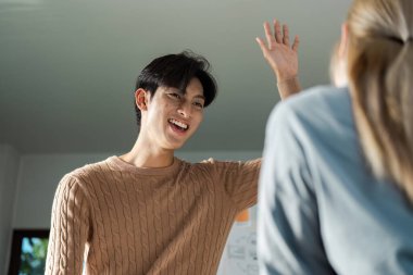 Odaklanmış bir tasarım ekibi, profesyonel bir ortamda takım çalışmasının ve yaratıcılığın özünü gösteren parlak bir ofiste işbirliği yapar..