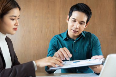 Bir iş görüşmesi sırasında, bir erkek kadın meslektaşına veri sunar, takım çalışması ve analizde etkili iletişim sunar..