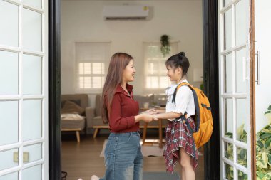 Okula gitmeden önce gülümsemeleri ve cesaretlendirmeleri yeni maceralar için sevgi ve heyecanı yansıtan bir anne ve kız arasında dokunaklı bir an..