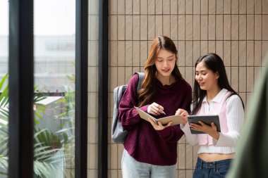 İki öğrenci materyallerini gözden geçirir, projelerinde işbirliği yapar ve parlak bir ortamda canlı bir çalışma seansının keyfini çıkarırlar..