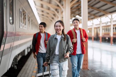 Neşeli genç bir kadın, bir trene yaklaşırken arkadaşlarına bavullarıyla önderlik eder, seyahat ve keşfin heyecanını yakalar..