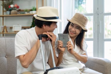 Yaşlı çift, pasaportlarını incelerken heyecanlı bir şekilde gülümsüyor, yaklaşan yolculuklarının beklentisiyle dolu..