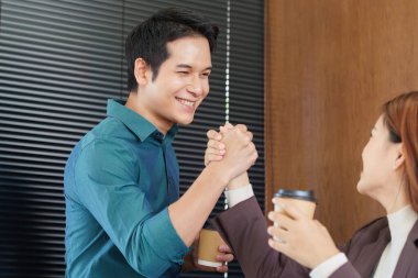 İki profesyonel, takım çalışmasının bir sembolü olan sıcak bir tokalaşma ve kahve paylaşımı ile başarılı işbirliklerini kutluyor..