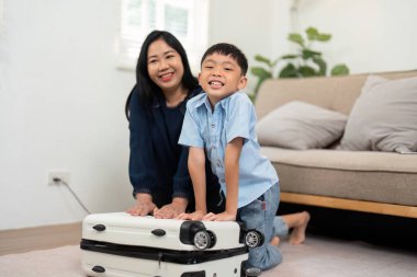 Bir anne oğlunun yaklaşan aile tatili için hem gülümseyen hem de heyecanlanan bavulunu toplamasına yardım eder. Sahne, seyahat hazırlıklarının ve bağlanma anlarının neşesini yakalar..