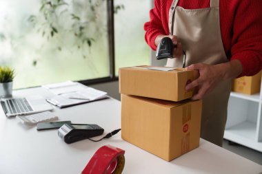 Çalışkan bir küçük işletme sahibi, iyi organize edilmiş bir çalışma alanında profesyonellik ve bakım ile nakliyat için ürünler topluyor..