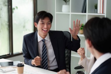 Enerjik bir ofis beyin fırtınası oturumunda genç bir profesyonel, takım üyeleri arasında sezgilerini, işbirliği ve coşkusunu paylaşıyor..