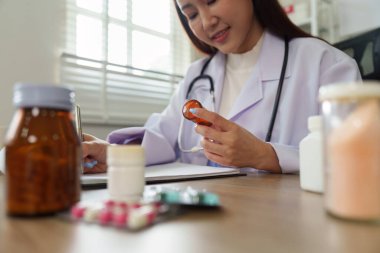 Bir sağlık uzmanı, ilaç tedavisini not alırken, doğru tedaviyi sağlarken ve hastalara özel bakım sağlarken yakından inceler..