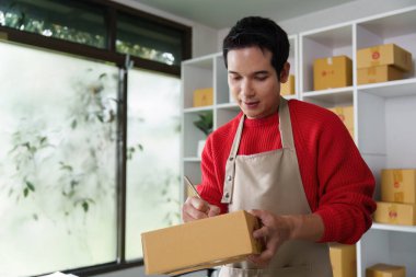 Teslimat için küçük işletme sahibi etiketleme paketleri, verimli bir çalışma alanında organizasyon becerileri sergilenir.