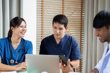 Üç tıp uzmanı, bir takım toplantısı sırasında hasta verilerini analiz ederek ve tedavi planlarını analiz ederek odaklanmış bir tartışmaya giriştiler..