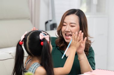 Bir anne ve kız arasında neşeli bir beşlik, öğrenmenin eğlencesini vurgulayarak, okula dönüş hazırlıklarının heyecanını yakalar..