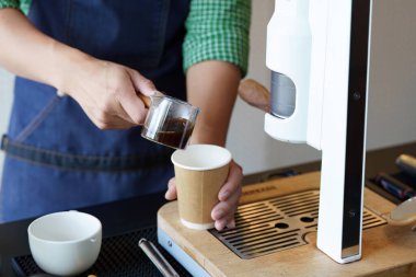 Yetenekli bir barista, biyo-çözünebilir bir fincana aromatik kahve dökerek, kafeterya endüstrisinde sürdürülebilir uygulamaları ön plana çıkarırken, aynı zamanda çevre dostu bir yaşam tarzını teşvik eder..