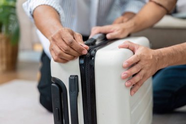 Bir çift valizlerinin fermuarını çekip seyahat planları için hazırlanırken ortak heyecan ve bağlılıklarını sergilerken görülüyor..