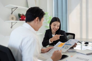 İki profesyonel, modern bir ofis ortamında vergi stratejileri, mali verilerin analizi ve raporlar hakkında bir tartışmaya girişti.