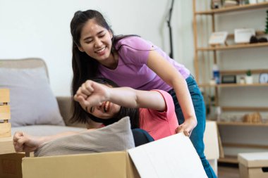 Neşeli bir eşcinsel çift hareketli bir kutunun içinde oturmuş, heyecan içinde yumruğunu kaldırırken, yeni evlerinde eğlence düşkünü ruhlarını sergiliyorlar..