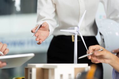 Sürdürülebilir bir tasarım modelini tartışan profesyoneller, modern bir çalışma alanında çevre dostu mimari stratejileri üzerinde işbirliği yapıyorlar..
