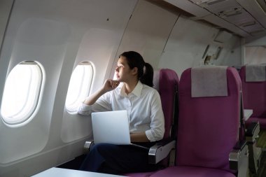 Bir iş seyahati yolcusu, pencerenin kenarında oturup, yolculuğunu ve gökyüzündeki gelecek fırsatlarını düşünür..