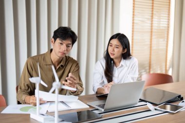 İki iş adamı arasında, rüzgar enerjisi çözümleri ve sürdürülebilirliği vurgulanan, yeşil teknoloji üzerine odaklı bir tartışma.