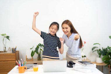 Bir öğretmen ve öğrenci, canlı bir eğitim ortamında motivasyon ve neşe ifade ederek öğrenme başarısını kutluyor..