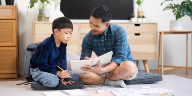 Bir baba oğluyla öğrenim seansına katılır, okuryazarlığı teşvik eder ve sıcak bir ev ortamında bağ kurar..