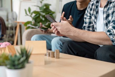 Finansal planlama tartışmasına katılan iki farklı yetişkin, konforlu bir ev ortamında tasarruf ve yatırımların yönetilmesinde işbirliği sergiliyorlar..