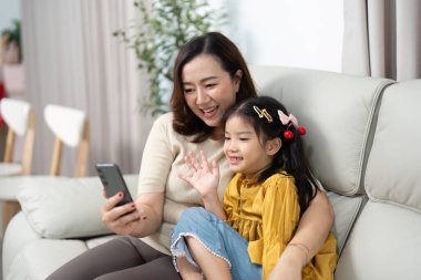 Bir anne ve kızı, aile sevgisini ve bağlantısını yansıtan bir video görüşmesinde neşeli bir anı paylaşıyor..