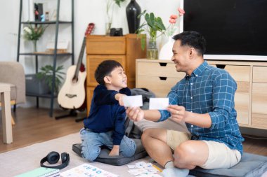 Bir baba ve oğul öğrenim materyallerini paylaşırken, eğitimin ve aile zamanının önemini artırırken neşeli bir anın tadını çıkarırlar..