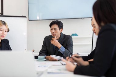 Profesyonellerden oluşan bir ekip stratejik bir planlama oturumuna katılıyor, proje ayrıntılarını analiz ediyor ve daha iyi sonuçlar için eyleme geçirilebilir görüşleri tartışıyor.