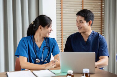 Bir doktor ve bir hemşire, bir takım toplantısında hasta bakımı stratejilerini tartışırken, işbirliği ve profesyonellik gösterirken kısa bir anı paylaşırlar..