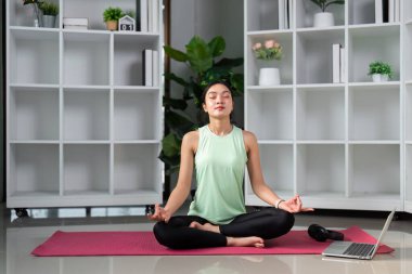 Huzurlu bir yoga alanında, bir kadın derin odaklanma ve nefes alma yoluyla farkındalık ve stres rahatlama yolculuğunu sergiliyor..