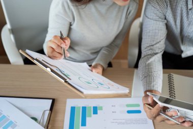 Meslektaşlar sürdürülebilir iş ölçümlerini analiz eder, eko-bilinçli bir ortamda veri güdümlü stratejileri tartışırlar.