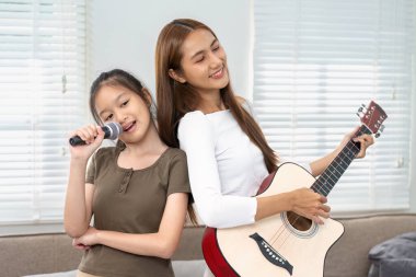 Bir anne ve kızı bir müzik düetini paylaşıyor, neşe ve sevgi dolu bir atmosfer yaratıyorlar, bağlarını kutluyorlar..