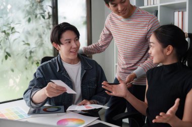 Tasarımcılardan oluşan bir ekip fikir ve renk örnekleri alışverişinde bulunarak, bir sonraki büyük UX UI projesi hakkında verimli bir diyalog içine girerek, işbirliğini vurguluyor.