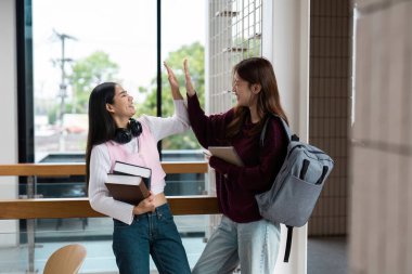 İki öğrenci işbirlikçi çabalarını bir beşlik çakarak, gösterişli bir yoldaşlık ve cesaret verici bir okul ortamında başarı sevinci ile kutluyor..