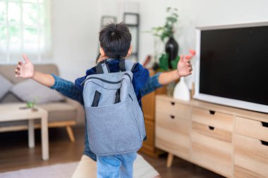 Genç bir çocuk okuldan eve dönerken heyecanlı bir şekilde bir aile üyesine sarılıyor. Sahne, aile desteğinin ve okula dönüş ruhunun özünü yakalıyor..