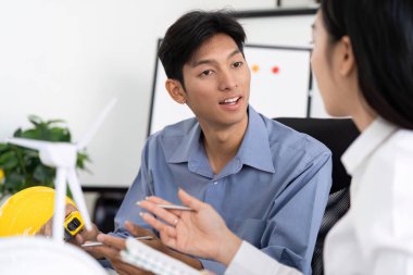 İki mühendis, yenilikçi fikirlerini görselleştirmek için tasarım modellerini kullanarak sürdürülebilir mühendislik uygulamaları hakkında canlı bir tartışmaya giriştiler..
